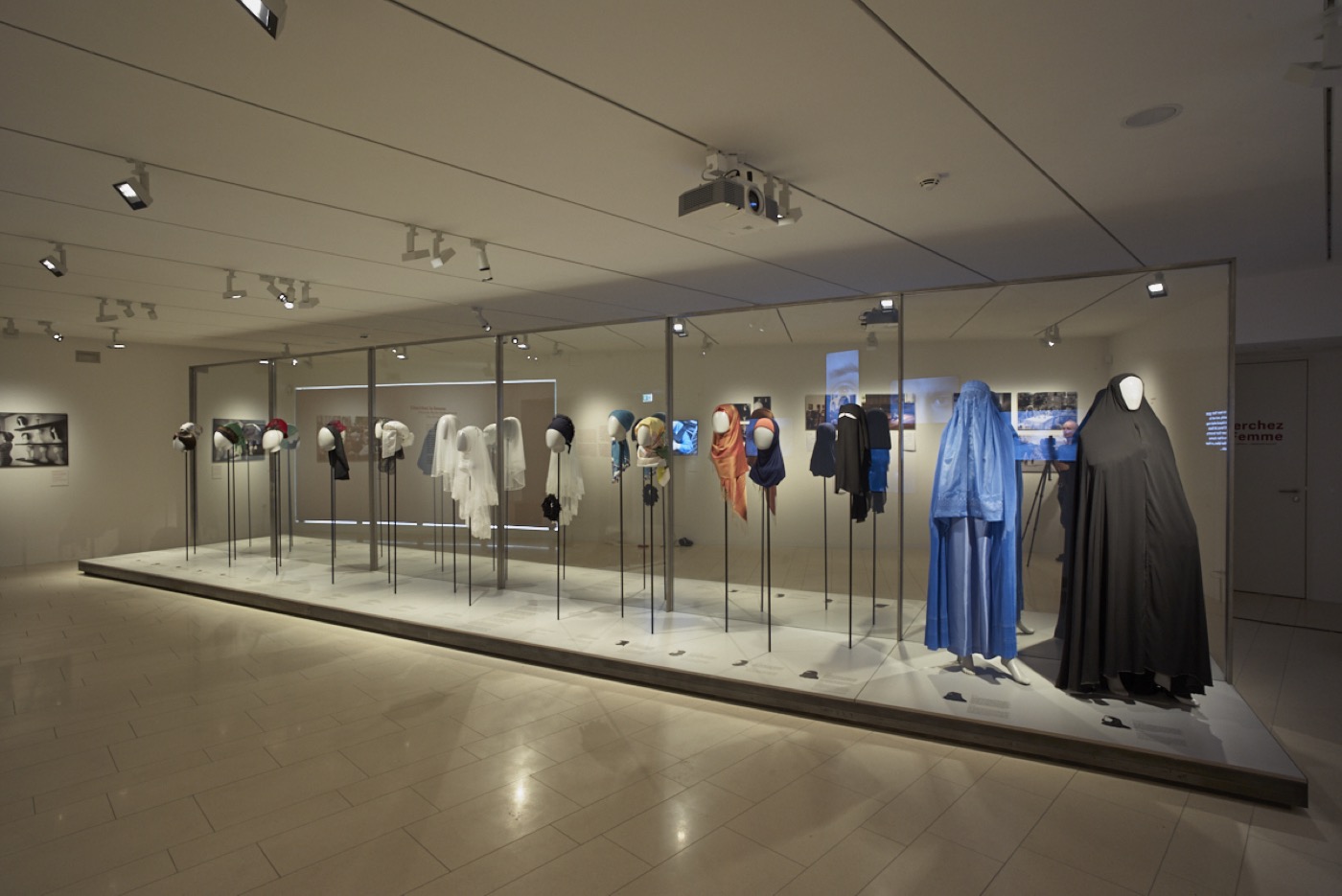 JMF Cherchez la femme, Ausstellungsraum im Erdgeschoss mit Schaufensterfiguren mit Kopfbedeckungen und Kleidung