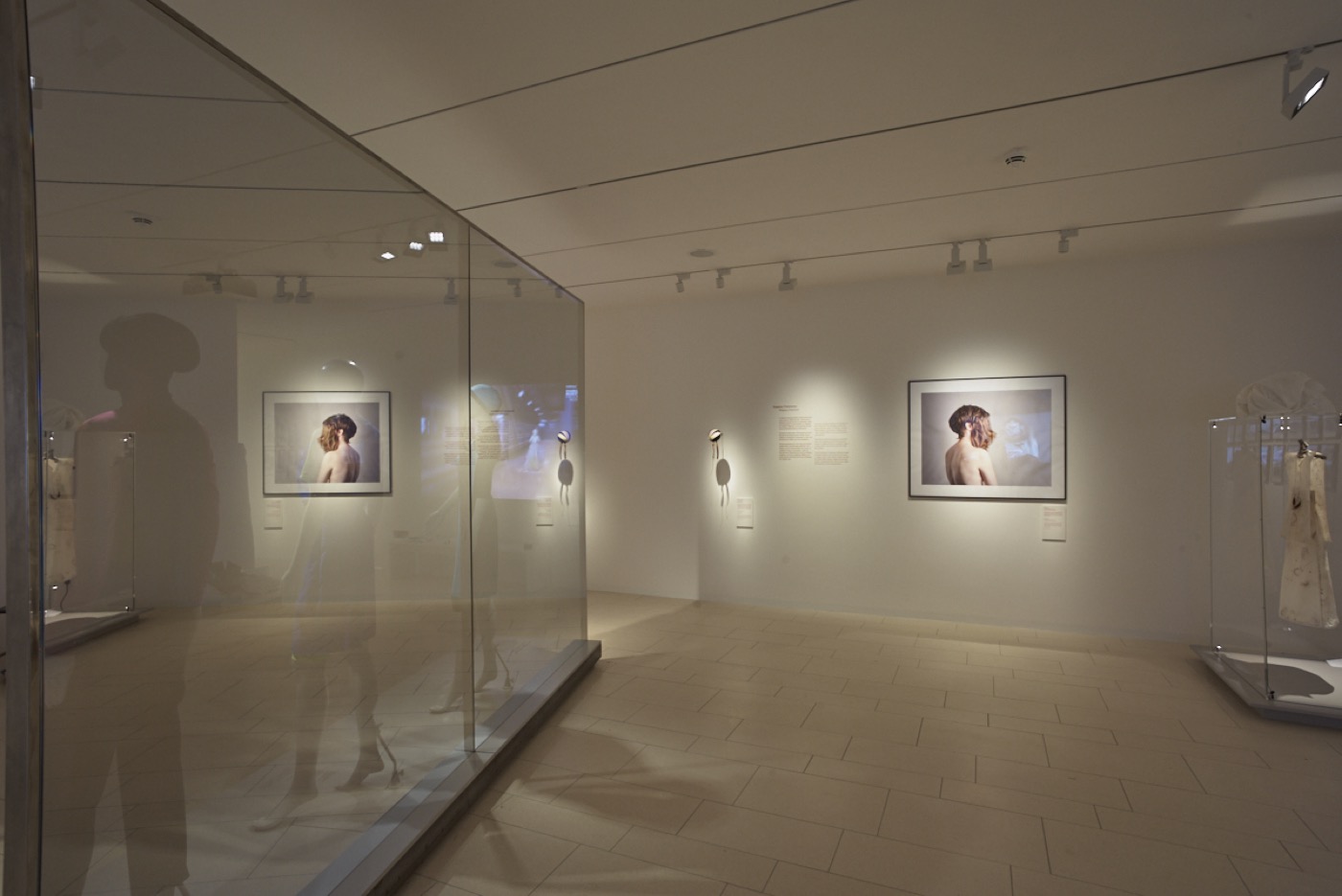 JMF Cherchez la femme, Ausstellungsraum im Untergeschoss mit Bildern und Kleid in Vitrine