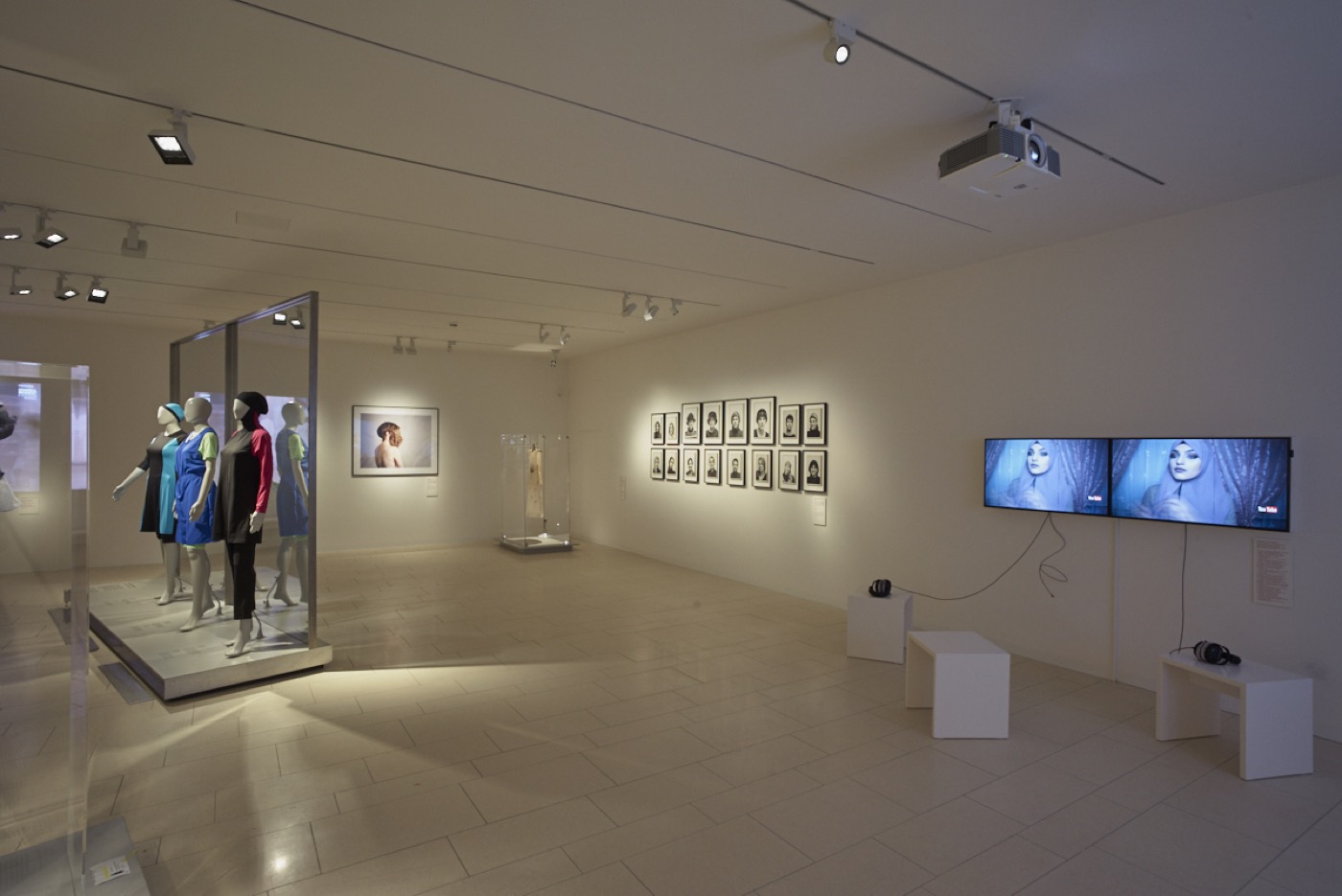JMF Cherchez la femme, Ausstellungsraum im Untergeschoss mit Medienstationen, Bildern und Schaufensterfiguren mit Kleidung